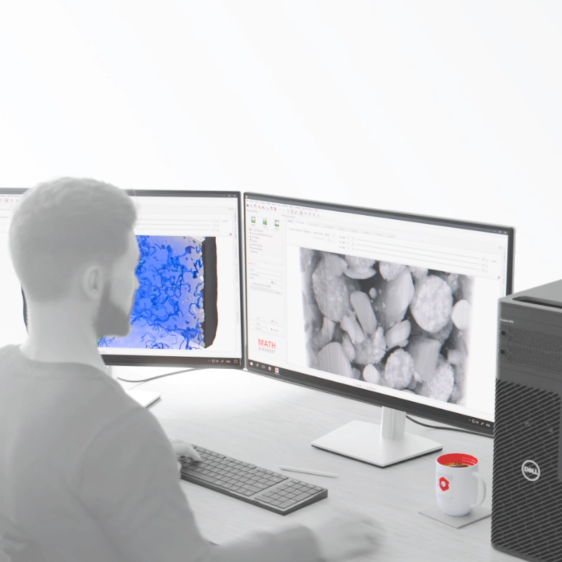 A user performing material analysis with GeoDict on a dual-monitor workstation, displaying a 3D microstructure and a simulation visualization